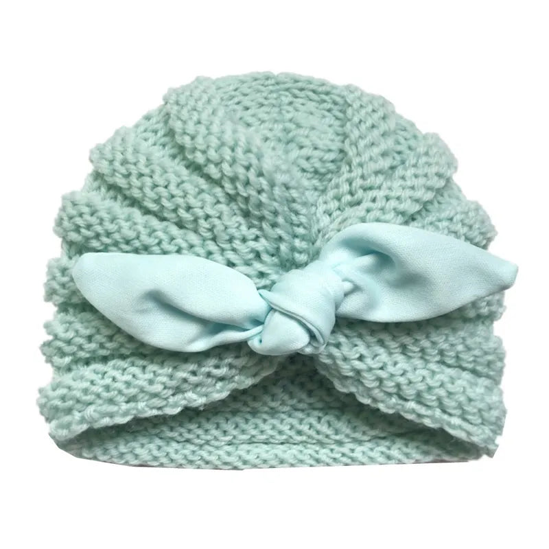 Candy color knitted baby beanie on a soft blanket, ideal winter bonnet for infants