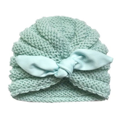 Candy color knitted baby beanie on a soft blanket, ideal winter bonnet for infants