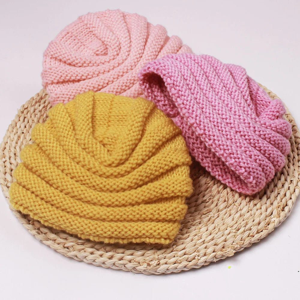 Toddler playing while wearing a warm knitted candy color baby beanie, comfortable winter hat