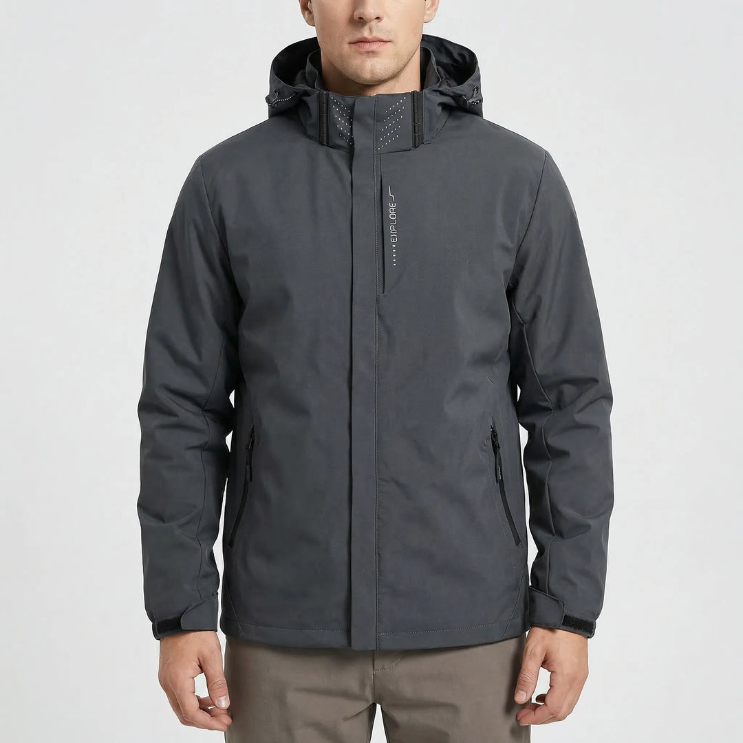 Man wearing a green lightweight hooded rain jacket, suitable for hiking, travel, and climbing gear.