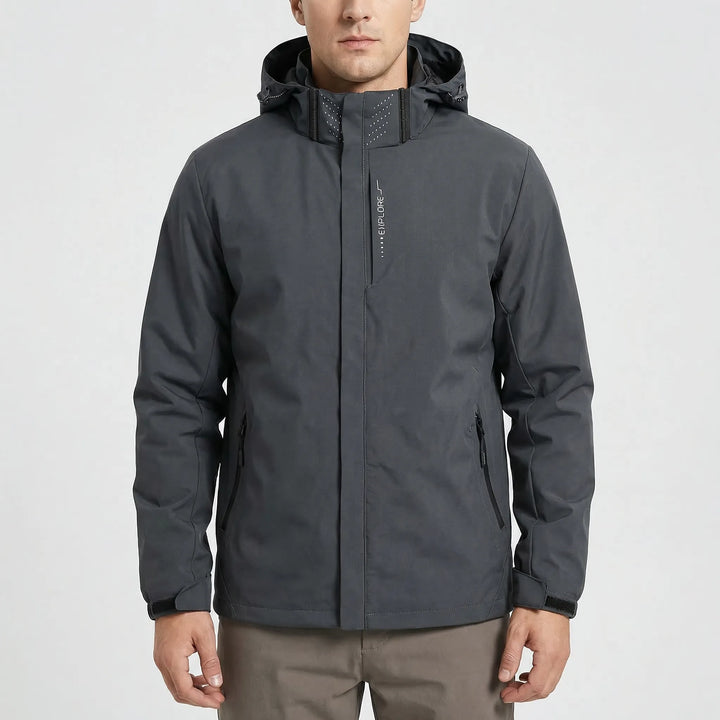 Man wearing a green lightweight hooded rain jacket, suitable for hiking, travel, and climbing gear.