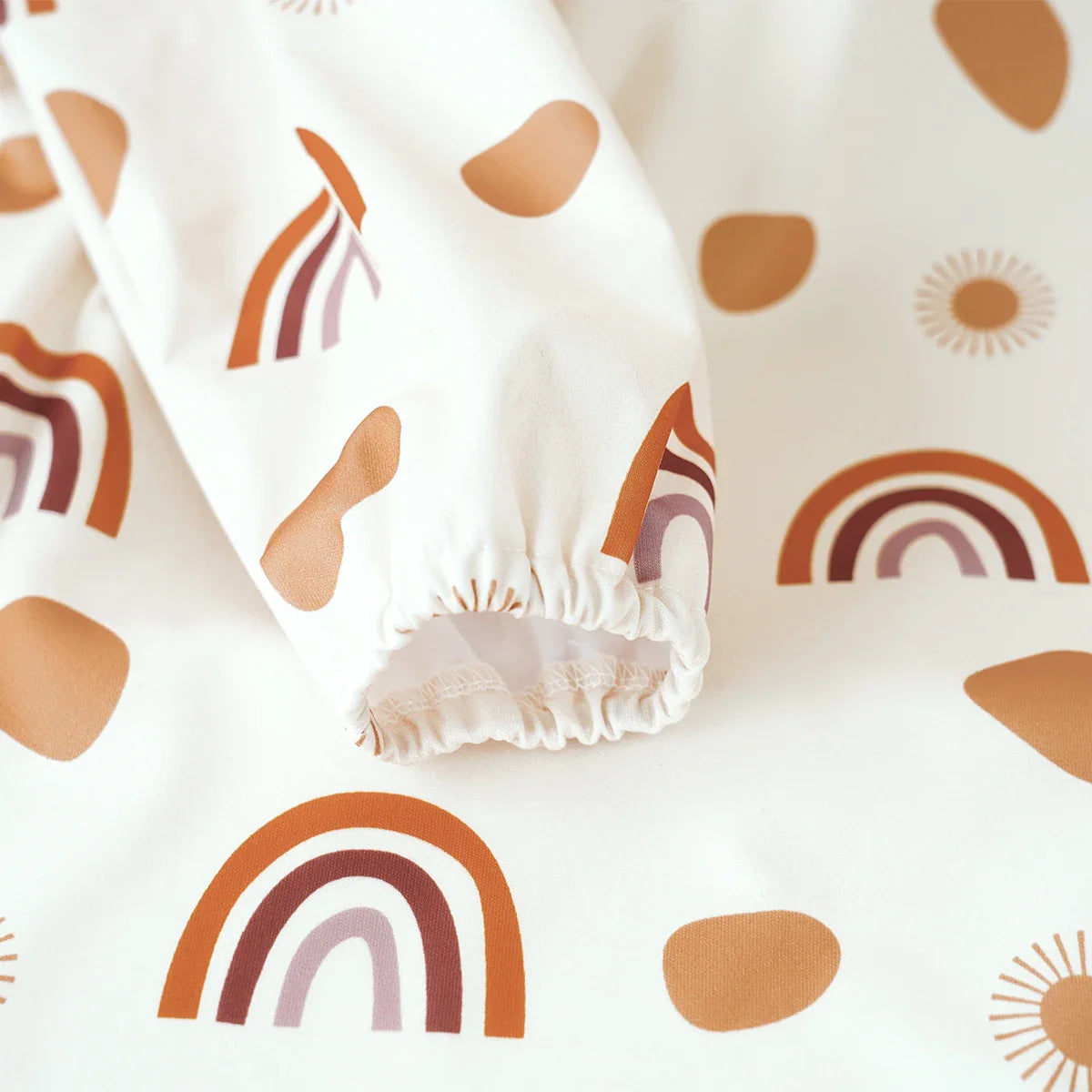 Waterproof baby bib, long sleeve design with an adjustable neck and built-in food catcher pocket.
