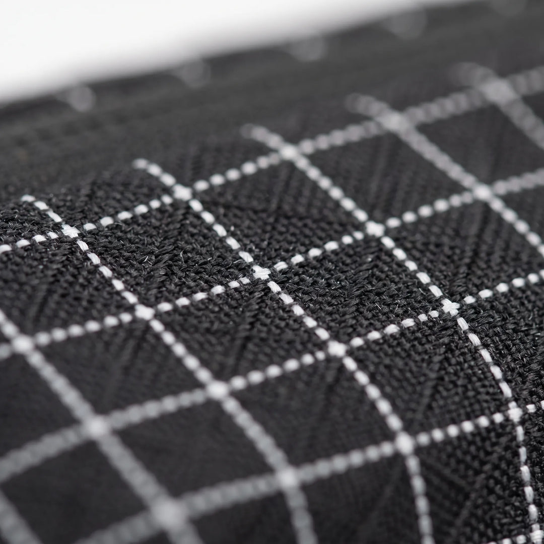 Close-up of the durable fabric and grid pattern of a versatile unisex sling bag, great for active use.