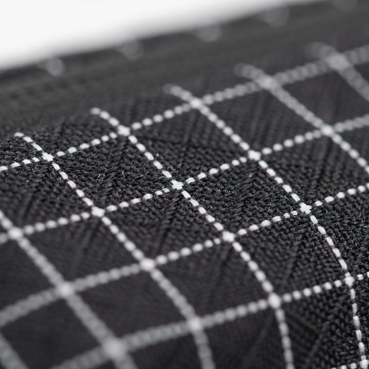 Close-up of the durable fabric and grid pattern of a versatile unisex sling bag, great for active use.