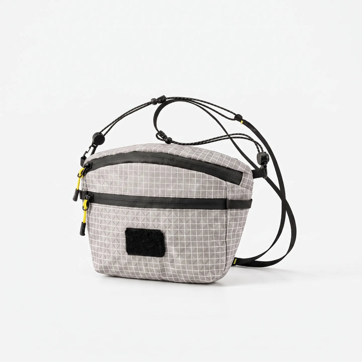 Back view of a black unisex grid chest bag with adjustable strap, suitable for comfortable crossbody wear.