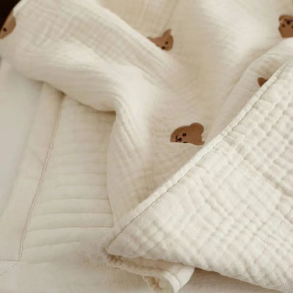 Unisex infant cotton blanket in cream, with a cute embroidered hedgehog, offering warmth without bulk.