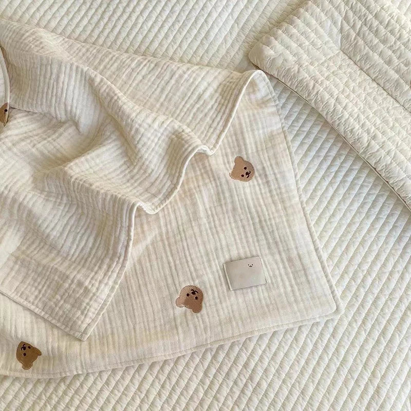 Close-up of a unisex cotton baby blanket showing detailed animal embroidery of a sleepy lion, baby soft and cozy.