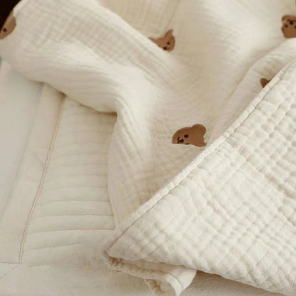 Folded newborn cotton blanket with charming embroidered bunny, suitable for nursery decor and summer use.