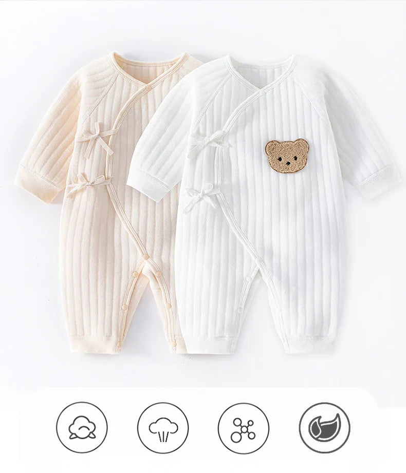 Flat lay of a plain white newborn cotton romper, essential unisex baby clothing