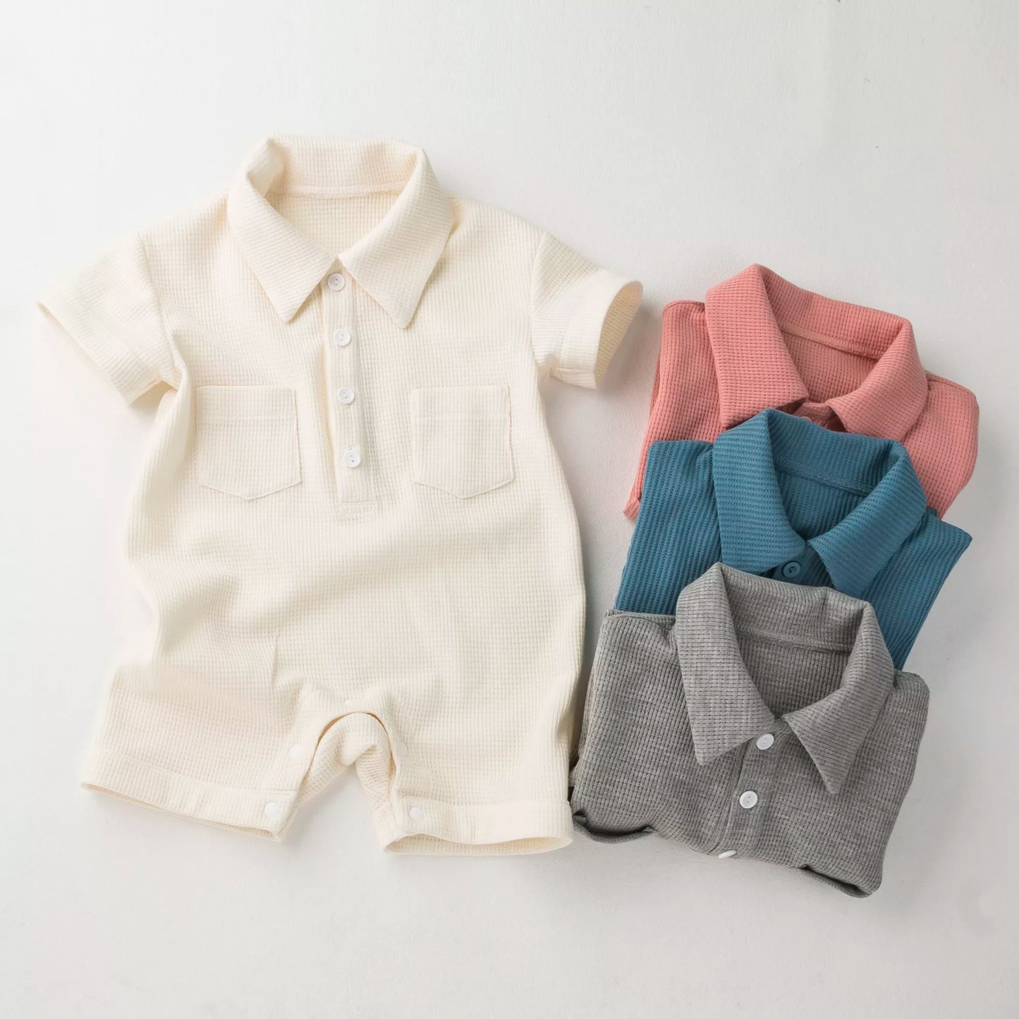 Unisex newborn short sleeve cotton jumpsuit in white, perfect for summer.