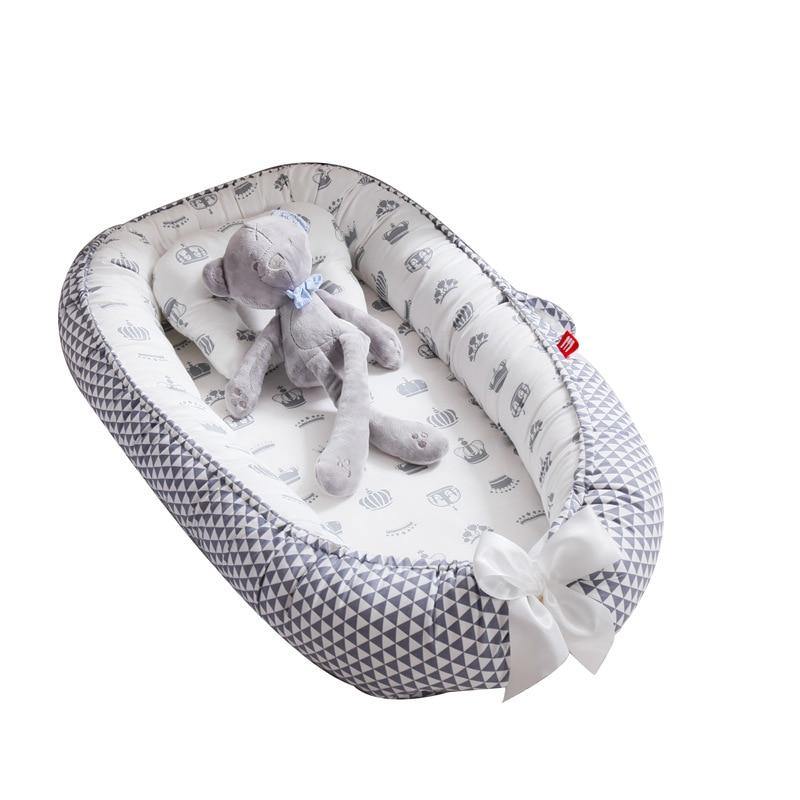 White and grey soft baby lounger, portable snuggle nest, provides a secure sleep space for infants