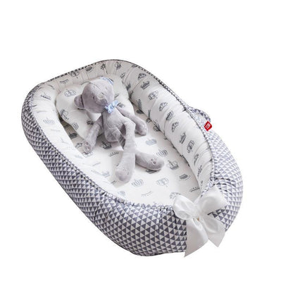 White and grey soft baby lounger, portable snuggle nest, provides a secure sleep space for infants