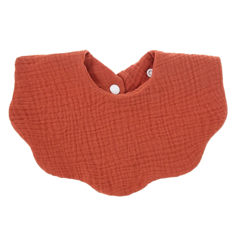 Mom fastening a premium soft cotton baby bib on her infant, highlighting ease of use and comfort