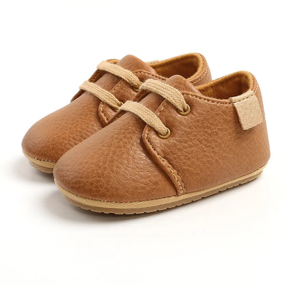 Side view of retro lace-up baby shoes in genuine black leather with soft sole