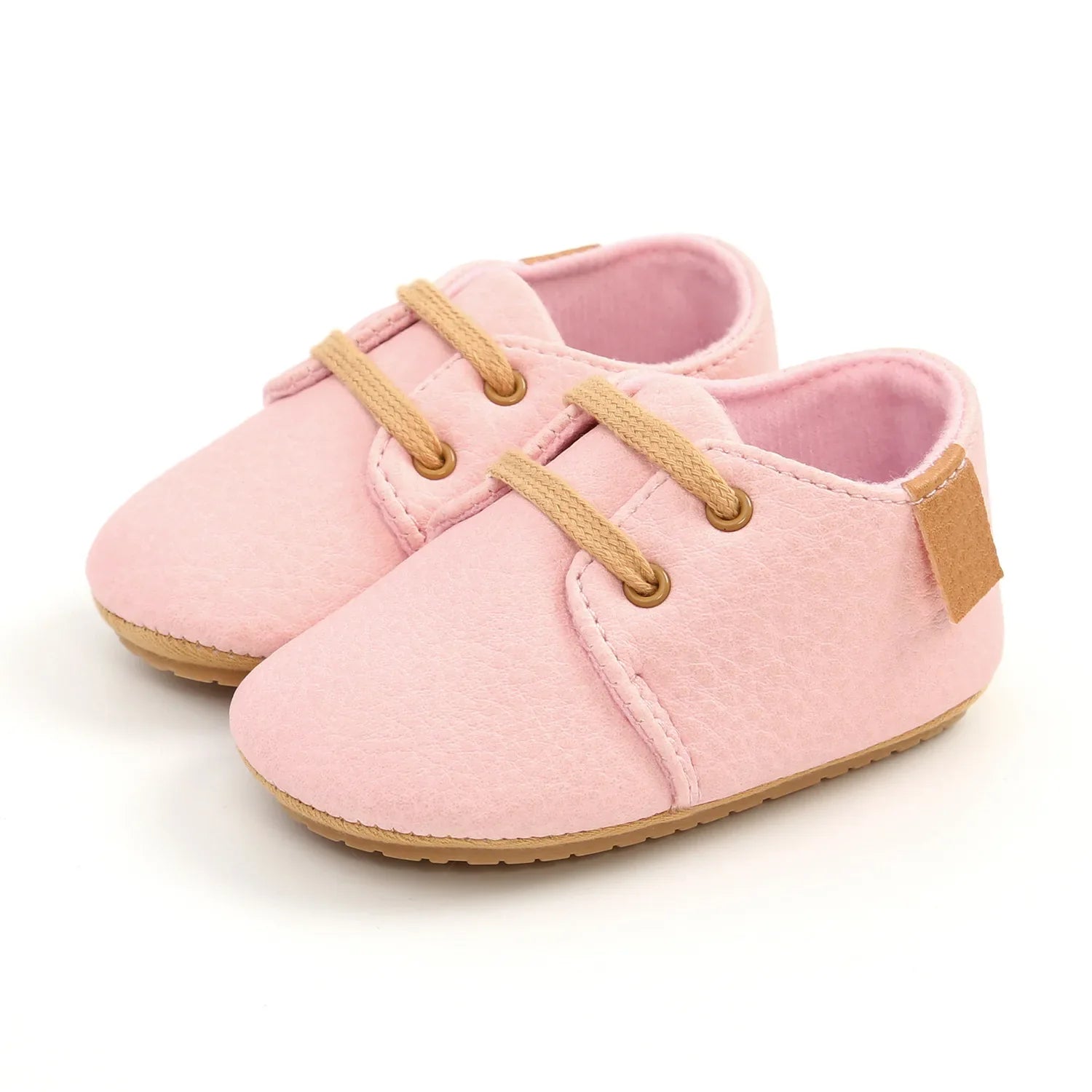 Baby sitting wearing black leather moccasins, showcasing soft sole and snug fit