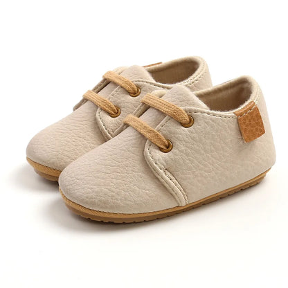 Close-up of tan leather infant moccasins, breathable and lightweight toddler shoes