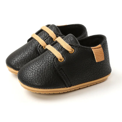 Side profile of lace-up retro baby shoes in tan leather, first walking footwear