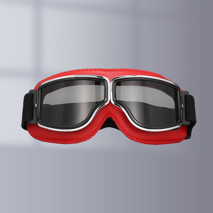 Vintage style riding goggles, black frame & tinted lenses for sun protection on motorcycles.