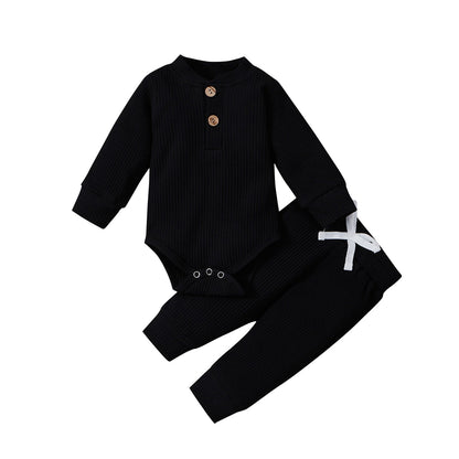 Detail of snaps on the bottom of a ribbed cotton long sleeve romper for easy changes