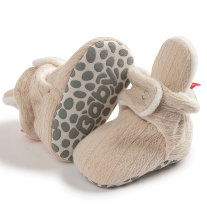 Close-up on hook and loop closure of unisex soft fluff baby booties, easy for infants.