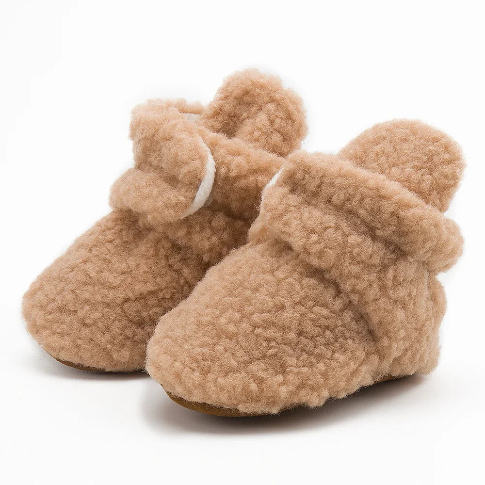 Infant wearing white unisex soft fluff baby booties, perfect as first walkers, warm and cozy.