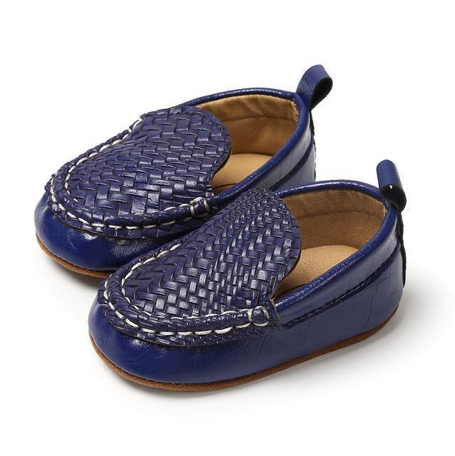 Close-up of brown leather infant moccasin boots, detailed stitching for baby's comfort and style