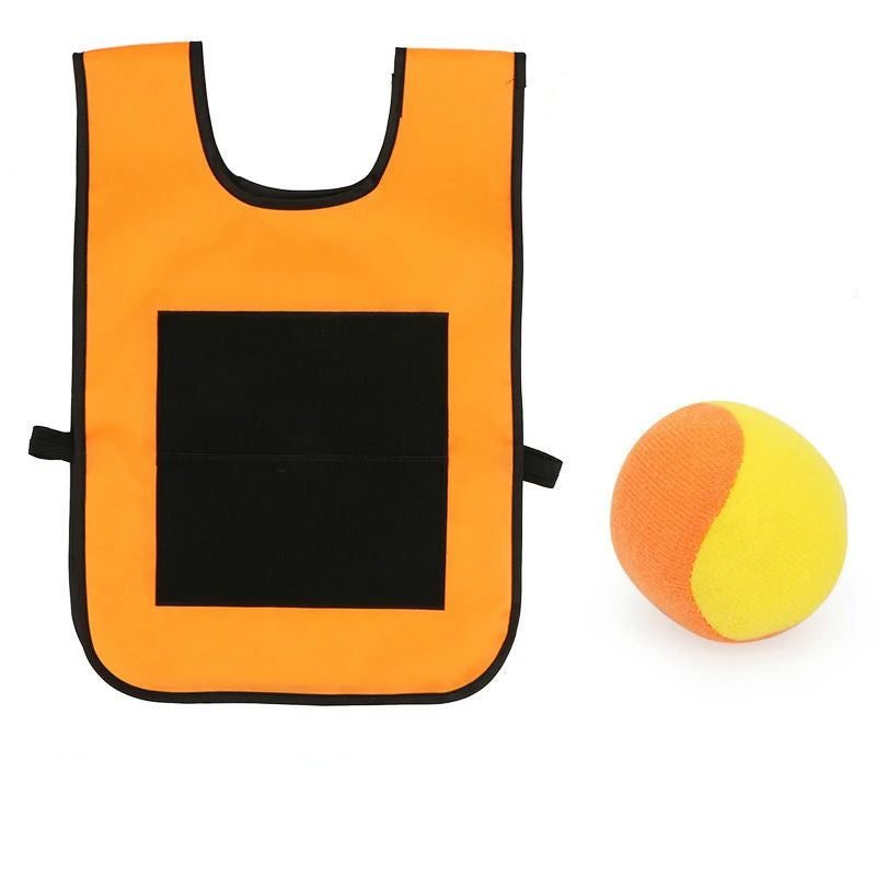 Child about to throw a ball at an adult wearing a sticky vest during outdoor game play