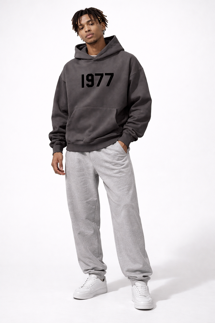 Warm unisex pullover hoodie with raglan sleeves and a vintage 1977 print, perfect streetwear.