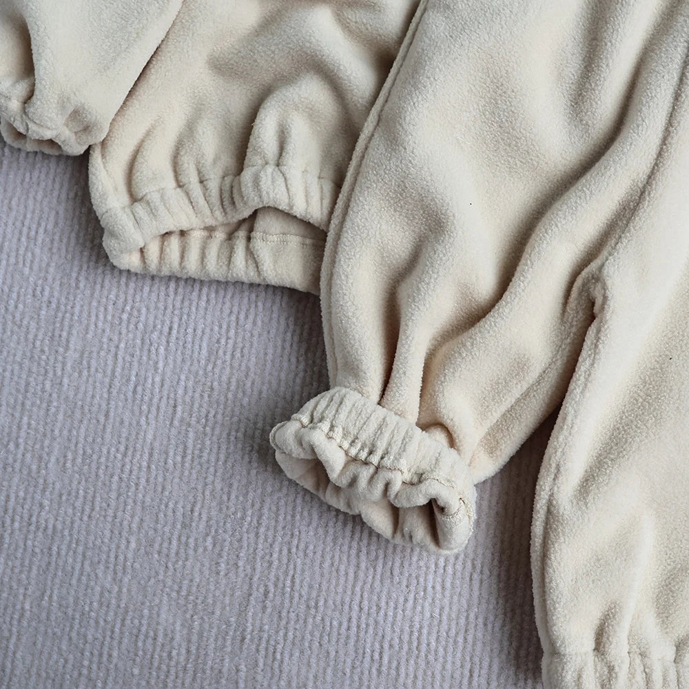 Cute toddler in a gray fleece track suit, ideal for outdoor autumn activities
