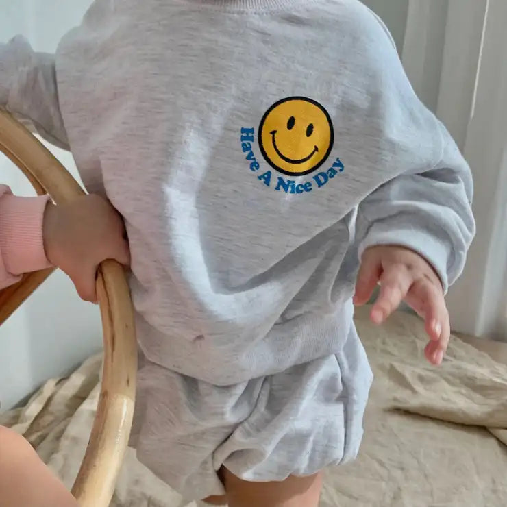 Adorable baby outfit: grey cotton sweatshirt with smiley face design and plain black shorts
