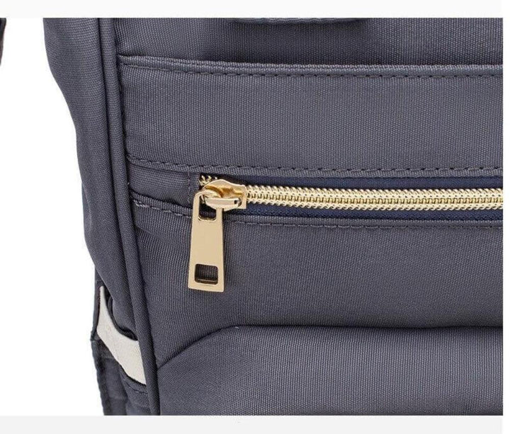 Modern grey unisex diaper backpack, a chic travel bag for parents. Features insulated pockets & ample space.
