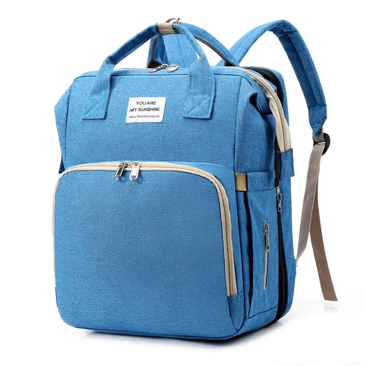 Durable unisex travel diaper bag with a spacious changing station & secure baby crib.