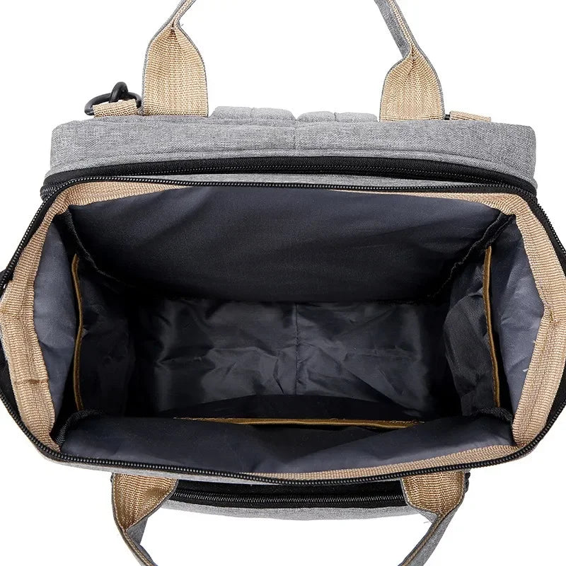 Grey unisex diaper bag transforming into a portable baby crib & changing mat.