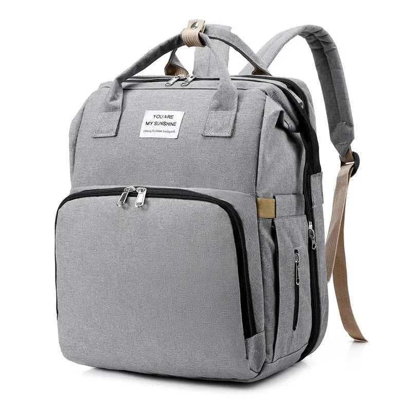 Compact travel diaper bag for parents, includes a foldable baby bed & changing area.