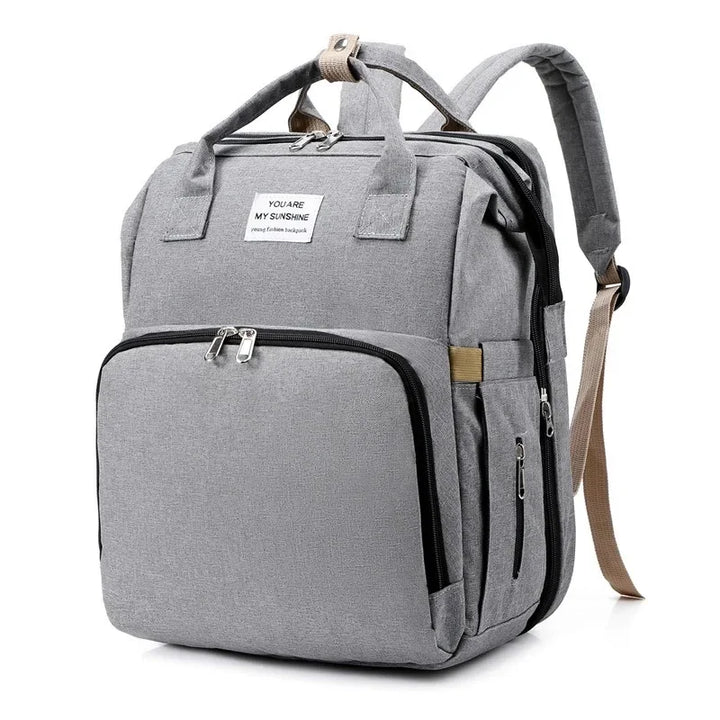Compact travel diaper bag for parents, includes a foldable baby bed & changing area.