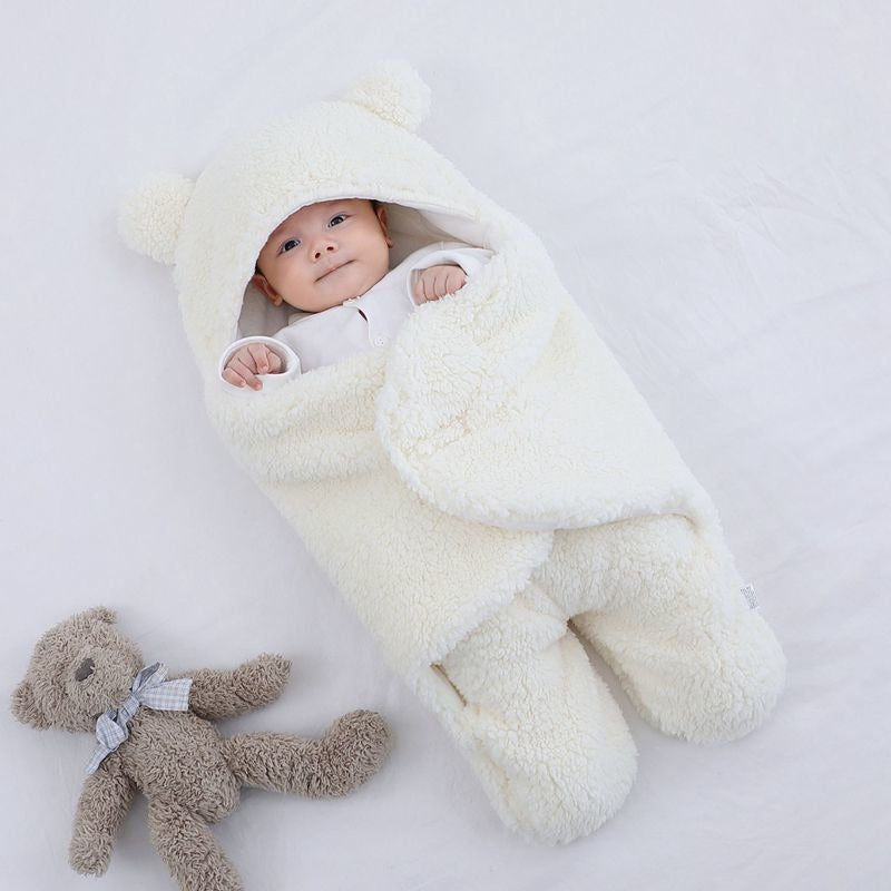 Unisex baby swaddle blanket draped over a crib rail, highlighting newborn essentials