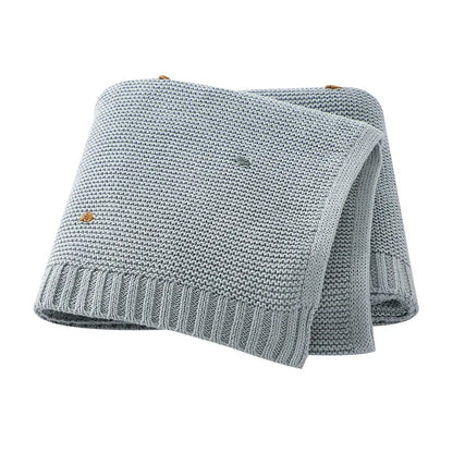Unisex knitted baby blanket laid flat, showcasing its full size, ideal for strollers and cribs