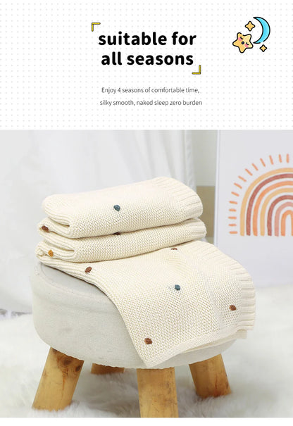 Nursery styled with a knitted baby blanket, adding a touch of cozy and practical bedding