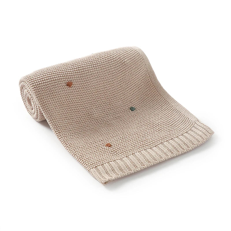 Close-up of a white knitted baby blanket, showcasing its ultra-soft texture, perfect for all seasons