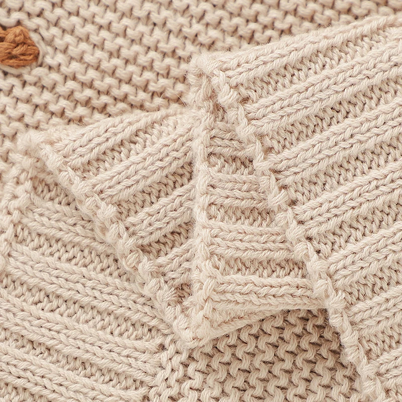 Knitted baby blanket draped over a crib, highlighting its soft texture, perfect for infant bedding