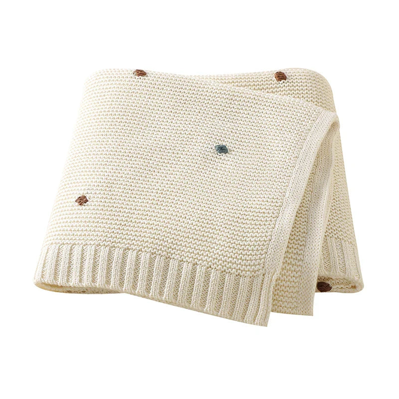 Detailed shot of the knit pattern on a unisex baby blanket, emphasizing its high-quality texture