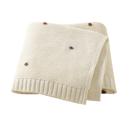 Detailed shot of the knit pattern on a unisex baby blanket, emphasizing its high-quality texture