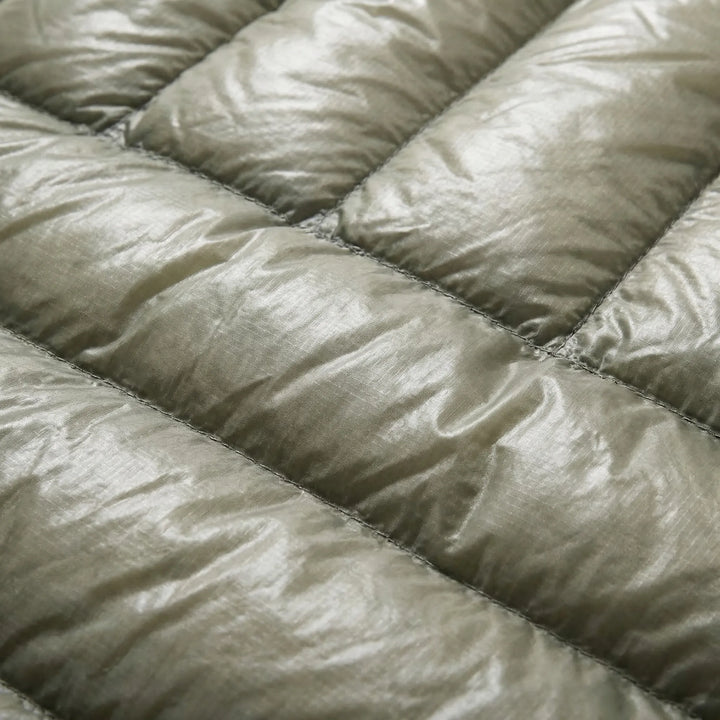 Compact ultralight down mummy sleeping bag, ideal for travel. Unisex design ensures warmth for backpackers.