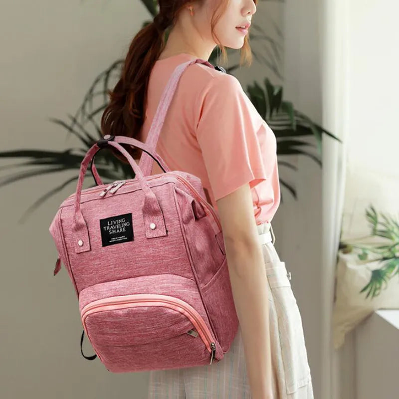 Front pocket of a large capacity waterproof diaper backpack, perfect for quick access items, parenting.