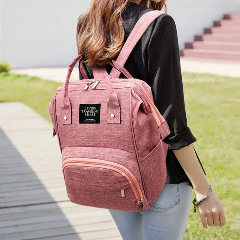 Unisex waterproof diaper backpack, presented with baby bottles and diapers, showcasing its large capacity.