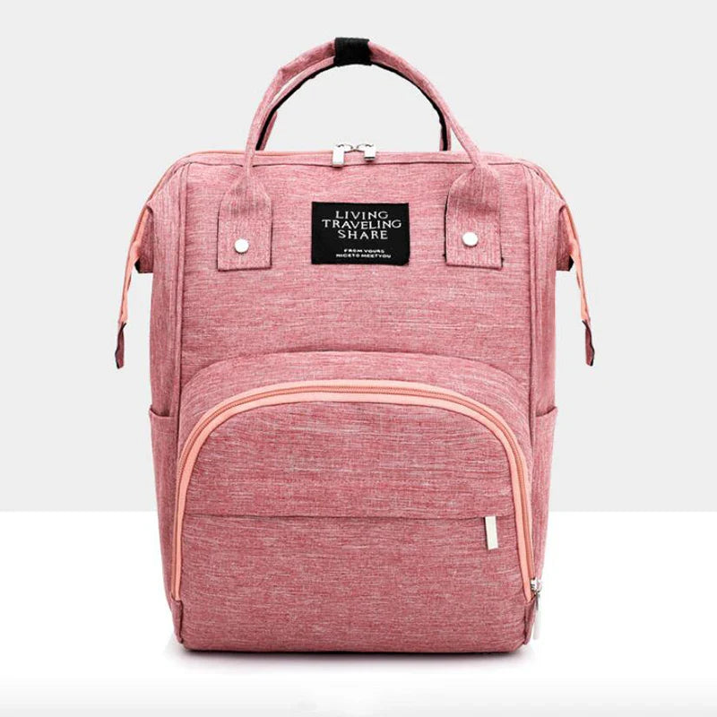 Unisex waterproof diaper backpack being packed with baby clothes and toys, highlighting its large capacity.
