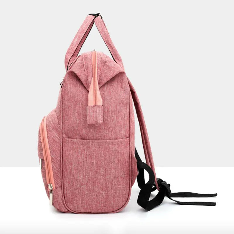 Unisex waterproof diaper backpack on a stroller, demonstrating its portability and convenience for baby travel.