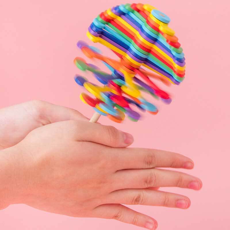 Hand spinning a colorful wooden lollipop fidget toy, showing its stress-relief motion and vibrant design.