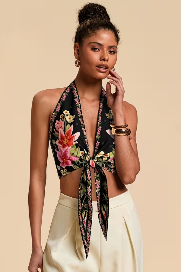 Close-up of a women's vibrant floral halter top with intricate flower designs. Summer fashion.