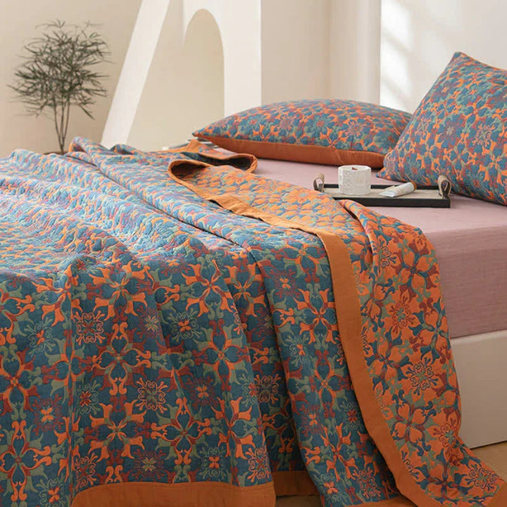 Detailed view of the six-layer cotton quilt's vibrant orange & blue textile pattern. Comfortable & warm bedding.